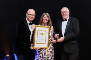 a woman stood with a gold framed certificate 