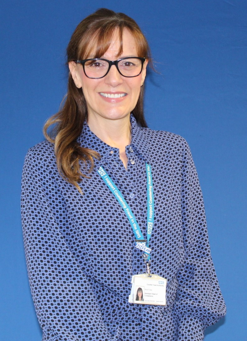 A woman wearing glasses and an NHS lanyard