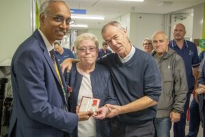 Ruth Knowles stands with neurosurgeons Mr Chittoor Rajaraman and Mr Gerry O'Reilly after presenting her husband's British Empire Medal to Ward 40