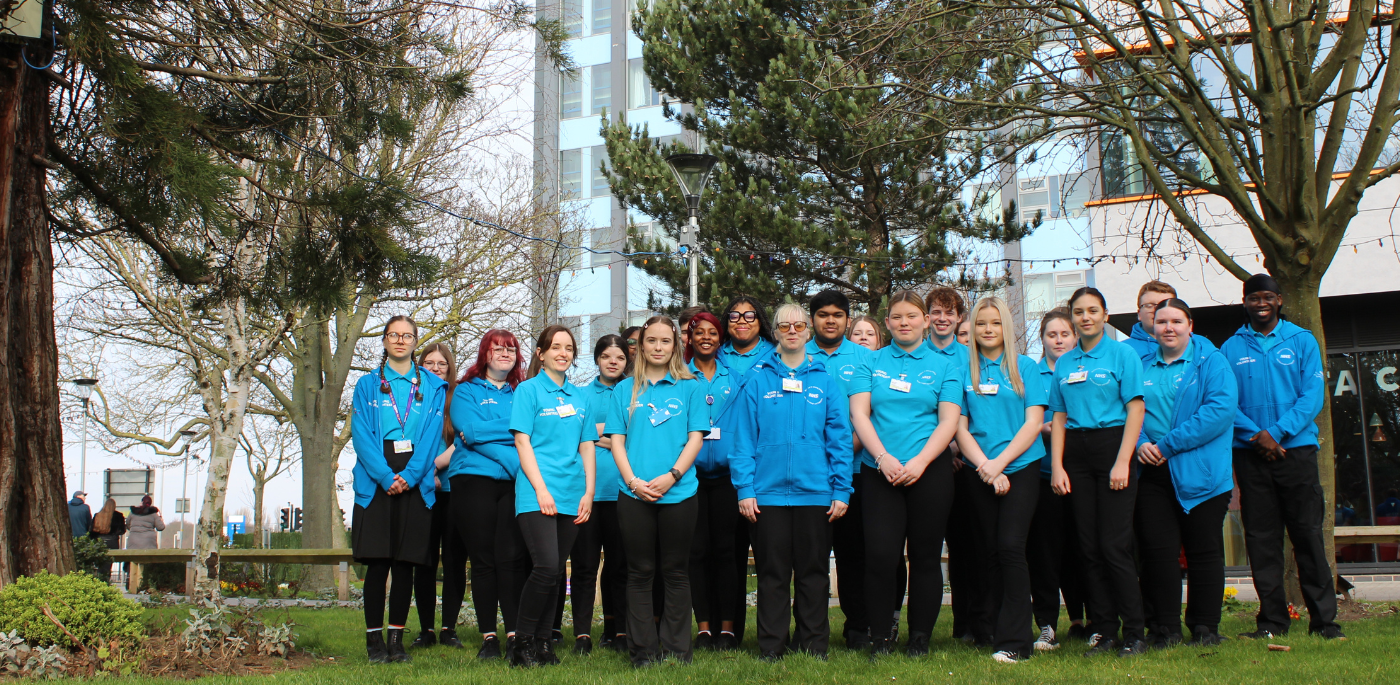 Humber Health Champions lined up on the grass outside the Hull Royal Infirmary tower Bbock