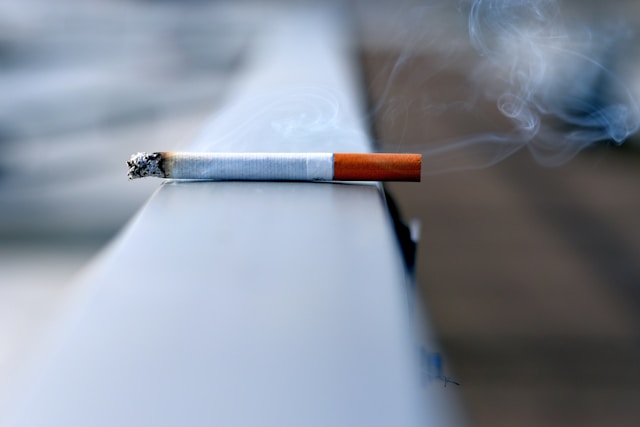 A smoking cigarette on a handrail